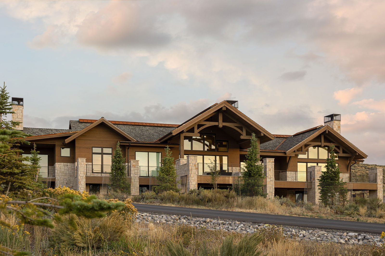 Rear elevation of custom mountain home with timber beams — Ensign Custom Homes